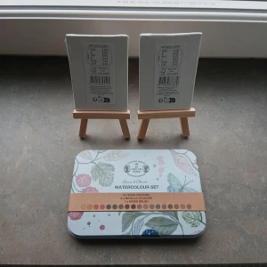 Watercolour Set - Perfekt för kreativa själar! Detta set innehåller akvarellfärger, pensel och två små målardukar med staffli. Skapa egna konstverk och låt fantasin flöda – passar både nybörjare och erfarna unga konstnärer.