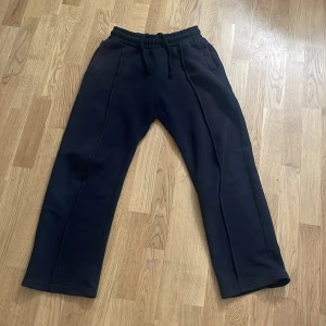 Svarta mjukisbyxor från Bershka XS - Sitter dig bra om du är 175-170cm lång. Svarta mjukisbyxor från Bershka i storlek XS. Byxorna har resår och snörning i midjan, raka ben och diskreta sömdetaljer längs framsidan. Mjukt material och fickor både fram och bak. Perfekta för chill dagar eller när du vill vara bekväm.