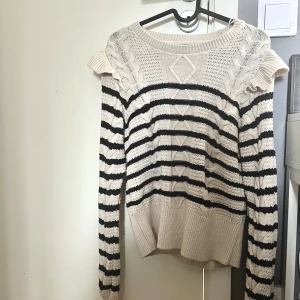Randig stickad tröja med volang - Säljer en beige och svart stickad tröja. Använd max 2 gånger, jätte snygg och super skön. Storlek Xs 
