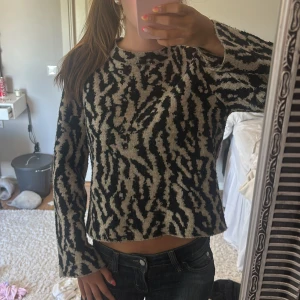 Mönstrad tjocktröja - mysig stickad tröja med beige och svart mönster. Tröjan har en rak, lite loose passform och långa ärmar. 