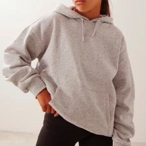 Grå hoodie med huva Gina young - Säljer en klassisk grå hoodie med huva och dragsko. Tröjan har en stor magficka och långa ärmar med ribbade muddar. Perfekt för en avslappnad stil och enkel att matcha med det mesta. Säljer på grund av att den inte kommer till nån användning och den är använd ett fåtal gånger💕