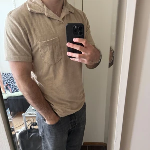 Beige kortärmad skjorta i manchester - Säljer en beige kortärmad skjorta i manchestertyg med klassisk krage och bröstficka. Skjortan har en avslappnad passform och är perfekt för varmare dagar. Enkel och stilren design som passar till mycket.