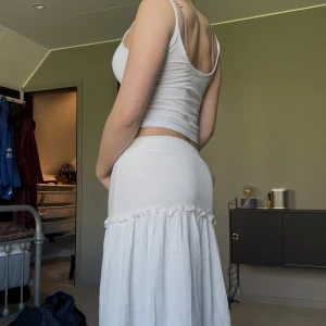 Vit långkjol från Chelsea - Säljer en vit långkjol från Chelsea med bred resår i midjan och volangdetalj nedtill. Kjolen är i ett tunt, luftigt material som passar perfekt till varmare dagar. Stl S. Hör av er om ni undrar något❤️