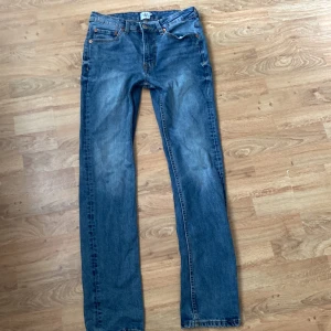 Blå raka jeans - Klassiska blå jeans med raka ben och normal passform. Jeansen har fem fickor, synliga nitar och dragkedja. Perfekta för en avslappnad stil och passar till det mesta.