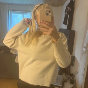 Vit stickad tröja från Zara - Säljer en vit stickad tröja från Zara i storlek S. Tröjan har en avslappnad passform med långa ärmar och ribbade muddar vid halsringning, ärmslut och nederkant. Perfekt för lager-på-lager och enkel att matcha.