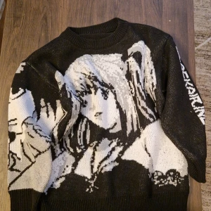 stickad Misa Deathnote tröja - Cool svart stickad tröja med stort vitt anime-motiv på framsidan och text på ena ärmen. Tröjan har rund hals och långa ärmar. Perfekt för dig som gillar streetwear och manga/anime-stil.