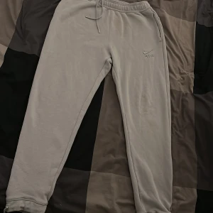 Grå mjukisbyxor från Nike Air - Säljer ett par grå mjukisbyxor från Nike Air med broderad logga på benet. Byxorna har dragsko i midjan och muddar vid bensluten. Perfekta för en avslappnad stil och riktigt sköna att ha på sig.