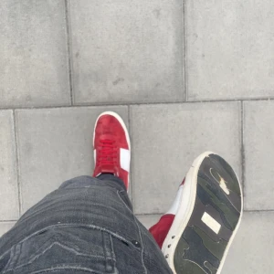 Röda sneakers med vita detaljer - Säljer ett par röda valentino flycrews sneakers med vita detaljer på sidorna och en markerad sula. Skorna är smått skadade men går att sy ihop. Saknar några nitar. Tar emot byten och priset går att ändra vid snabb affär! Defekter finns på innersidan av skon och lite på yttersidan. Skriv privat för bild 