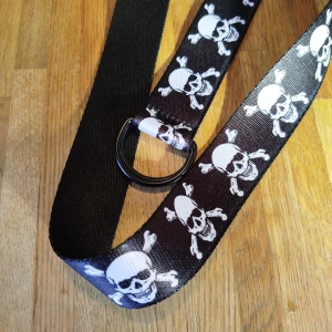 Skärp - Skärp med dödskallar. 132cm långt. Använd ett fåtal gånger.