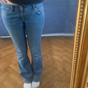 Blå bootcut jeans - Säljer ett par blå bootcut jeans med låg midja. 