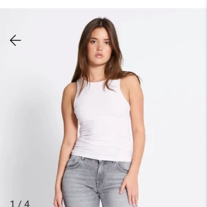 Vit ribbad linnetopp - Säljer en enkel och stilren vit ribbad linnetopp med tight passform. Toppen är ärmlös och har rund halsringning, perfekt för varma dagar eller som layering-piece.