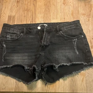 Svarta jeansshorts med fransar från H&M - Säljer ett par svarta jeansshorts från H&M i storlek 38. Shortsen har fransig kant nertill, slitna detaljer💞