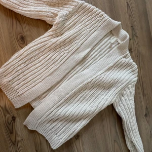 Vit kabelstickad kofta - Stor, mysig kabelstickad kofta från HM. Modellen är lite oversize och är inte det minsta sticksig. Endast använd en gång.