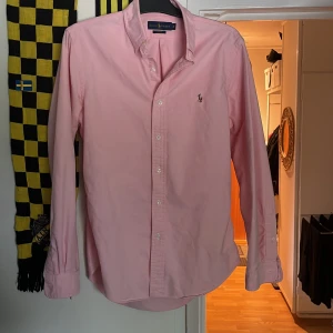 Rosa raffe skjorta  - En rosa Ralph Lauren skjorta, Oxford. Använd flera gånger men fortfarande i fint skick! Storlek:M - Slim Fit