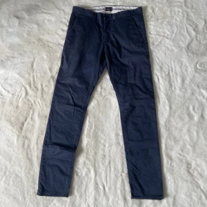 Jättesnygga mörkblåa chinos från märket Martinique  - Superfina klassiska mörkblåa chinos ifrån märket Martinique i storlek 32/34 de är i bra skick och är perfekta nu inför alla speciella tillfällen i sommar som balen, studenten, examen, till olika middagar eller bara till vardagen då de är ett perfekt basplagg⭐️ De är väldigt sköna/mjuka, är i bra material/kvalitet,bra passform, är unika och passar till allt👍🏻De är i modellen slim fit och stylen ser man på bilden med lappen. Skriv om funderingar, lämna gärna omdöme om köpt och priset kan diskuteras😊