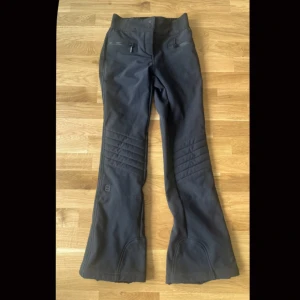 Svarta täckbyxor med dragkedjor - Svarta täckbyxor från 8848 med markerade sömmar över knäna och dragkedjor vid bensluten. Byxorna har fickor med dragkedja framtill och är tillverkade i ett slitstarkt material som passar för vintern. Köpta 2022 och använda 2 gånger ✨💖