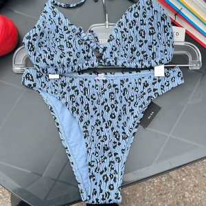 Bikini i blått leopardmönster - Säljer en superfin helt oanvänd bikini från Nakd, prislappar är kvar. Underdelen är i storlek xxs och överdelen är i M. 80kr tillsammans plus frakt, välj gärna instabox om möjligt