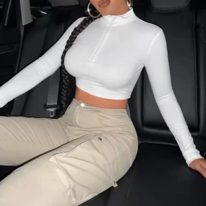 Vit croppad långärmad polotopp - Säljer en stilren vit croppad långärmad polotopp med dragkedja framtill. Aldrig använt passade inte min stil men glömde returnera.