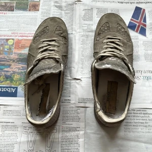 GAT sneakers S/S 18 - GAT sneakers i beige mocka med paneler i ormskinnsmönster. Skorna har snörning, rund tå och platt sula. Unik design med klassisk siluett och detaljerad textil på insidan.