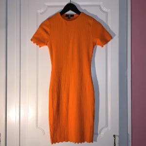 Missguided, strl 34 - En orange tight klänning från Missguided i storlek 34. Mycket fint skick förutom en liten, liten fläck på högra sida krage (VG se sista bilden).  Levereras nytvättad.  Postar samma dag som betalning gjorts!  Om du har några frågor får du gärna höra av dig.  Mvh 