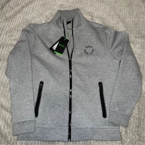 Hugo Boss - Skaz Full-Zip Light Grey - Säljer en helt ny Hugo Boss - Skaz Full-Zip Light Grey. Nypris är 1999 kr. Storlek L.