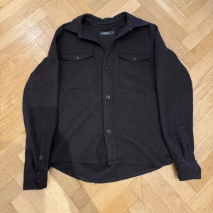 Mörkbrun overshirt - Säljer en mörkbrun ullovershirt från Dressman med två bröstfickor och knäppning. Storlek S, skick 8/10 inte använd så jättemycket. Pris går att diskutera vid snabb affär💰. Tveka inte att höra av dig vid frågor, funderingar eller priförslag!!