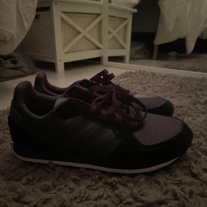 Svarta Adidas sneakers  - Säljer ett par snygga Adidas sneakers i svart. Skorna har klassiska tre ränder på sidan och en platt sula. Perfekta för vardagsbruk och har en sportig look. Helt nya och storlek 37 1/3. Pris kan diskuteras❤️