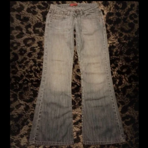 Ljusblå bootcut jeans - Säljer ett par ljusblå bootcut jeans. Jeansen har låg midja och är i ett mjukt denimtyg. Perfekta för dig som gillar en avslappnad och tidlös stil.                                    Ytterbenslängd: 93cm  Innerbenslängd: 71cm  Midja: 36cm  Benslutets bredd: 26cm  Lår: 24cm