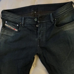 Mörkblå jeansbyxor från Diesel - Säljer ett par mörkblå jeansbyxor från Diesel med flerknappsgylf. Jeansen är i bootcut, och för långa på mig som är 163 cm. Byxorna är aldrig använda. Byxorna passar en S/Xs - tall. 