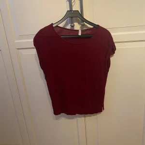 Vinröd t-shirt från H&M - En enkel vinröd t-shirt från H&M Basic med rund halsringning och korta ärmar. Super mjukt material och faller fint på en. I strl S
