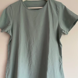 Ljusgrön t-shirt från Take Off - Säljer en enkel och stilren ljusgrön t-shirt från Take Off. T-shirten har rund halsringning och är tillverkad i mjuk bomullsblandning med lite stretch för extra komfort. Perfekt basplagg till garderoben.