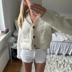 Vita fransiga shorts från Zara - Säljer ett par vita shorts från Zara med fransiga kanter och klassisk femficksdesign. De har en dragkedja och knapp framtill. Perfekta för sommardagar!💘