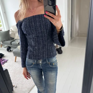 Mörkblå offshoulder topp från Zara - Trendig mörkblå offshoulder topp från Zara med vitmelerat rutigt mönster. Säljer då den tyvärr inte kommer till användning😓 Toppen har långa ärmar och en figurnära passform som framhäver siluetten.  Hör av er vid fler frågor💓💓