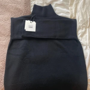 Svart stickad polotröja från Soft Goat - Säljer en svart stickad polotröja från Soft Goat. Tröjan har hög polokrage och är i 100% kashmir. Använd enstaka gånger