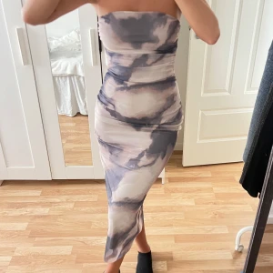Tubklänning Stradivarius  - Säljer en snygg tubklänning med figurnära passform och abstrakt mönster i blått och beige. Andvänd en gång, funkar för både fester, sommar kvällar. 