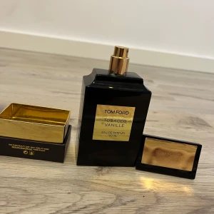 Tom Ford Tobacco Vanille Eau de Parfum 100 ml - Lyxig parfym från Tom Ford i doften Tobacco Vanille. Flaskan är svart med gulddetaljer och rymmer 100 ml. Kommer i originalförpackning med elegant svart och guld design. Perfekt för dig som gillar varma och kryddiga dofter.