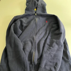 Mörkblå hoodie från Polo Ralph Lauren - Säljer en mörkblå hoodie från Polo Ralph Lauren med dragkedja och huva. Storlek s/170