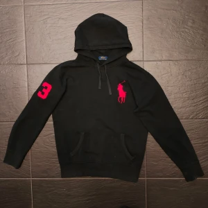 Ralph Lauren big pony hoodie  - Säljer en Ralph Lauren big pony hoodie I svart med röda detaljer. Ganska sällsynta. Funkar perfekt till en vårdag/sommarkväll. Skriv vid minsta fundering!