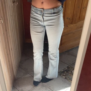 Ljusblå bootcut jeans - Säljer ett par ljusblå jeans med bootcut-modell och klassisk femficksdesign. Jeansen har normal passform och är tillverkade i denim med lätt stretch. Perfekta för dig som gillar en tidlös look med lite utsvängda ben.