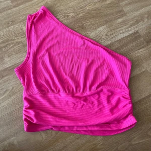 Rosa ribbad oneshoulder topp - Säljer en snygg rosa ribbad topp med oneshoulder-design. 