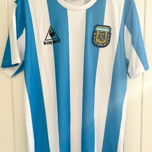 Diego Armando Maradona - Argentina VM 1986 - Säljer en klassisk fotbollströja, Diego Armando Maradonas  argentinska matchtröja från VM 1986. Tröjan är en remake i nyskick. Aldrig använd.  Large, normal i storleken.  Skickar inom 24 h.  #fotboll