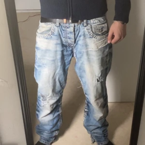 Jeans - Säljer ett par snygga blå jeans från Cipo & Baxx med coola slitningar och unika detaljer på bakfickorna. Lite lagningar här o där. Skicka pm för för fler bilder eller annat