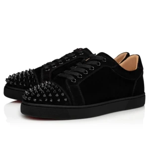 Svarta sneakers med nitar från Christian Louboutin - Säljer ett par svarta sneakers från Christian Louboutin med ikonisk röd sula och svarta nitar på tån. Skorna har snörning och en platt sula. Perfekta för dig som vill sticka ut med en lyxig och edgy stil.