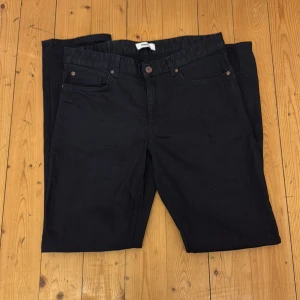 Svarta jeansbyxor från Kappahl - Säljer ett par svarta jeansbyxor från Kappahl med klassisk femficksdesign och normal passform. Byxorna har knapp och dragkedja i gylfen samt bälteshällor. Perfekta till vardags för en stilren look.