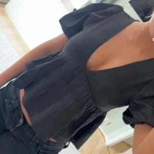 Svart blus med puffärmar och v-ringning nelly  - jätte söt svart blus med djup v-ringning och korta puffärmar. storlek 36 från nelly helt ny 