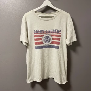 Saint Laurent T-Shirt  - ‼️VI TAR EJ BYTEN‼️ Saint Laurent T-Shirt  | Skick: 7/10 | Storlek (S), passar (M)  | Fraktar inom 24H efter köp på köparens bekostnad 📦💨 | Hör av dig vid minsta fråga eller fundering 💭