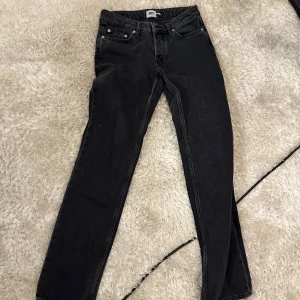 Svarta jeansbyxor 457 straight fit - Svarta jeansbyxor från 457 med klassisk femficksdesign och raka ben. Jeansen har en enkel look och är tillverkade i denim med en mörk tvätt. Perfekta för dig som gillar en clean och tidlös stil.