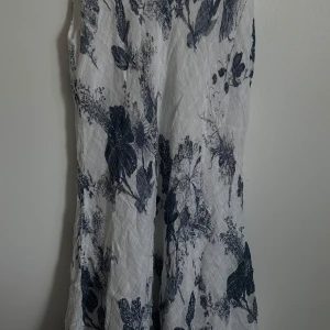 vit blommig klänning i linne - så fin vit klänning med mörkblåa blommor, i linnematerial. oklart vilket märke och strlk, men har stylat den med ett bälte så har det sett så snyggt ut (som XS/S). kommer till nedom knäna på mig som är 160 ish ✨