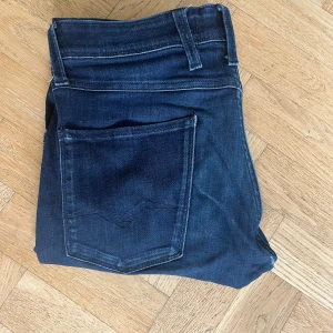 Mörkblå skinny jeans från Replay - Snygga mörkblå skinny jeans från Replay med klassisk femficksdesign och diskreta slitningar. Jeansen har normal midja och är tillverkade i stretchigt denim för en bekväm passform. Perfekta till sneakers eller boots.