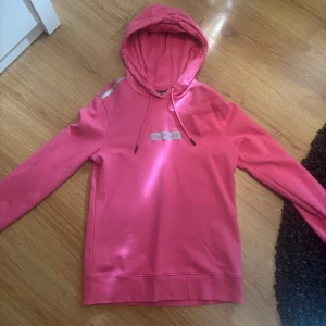 Rosa hoodie från Calvin Klein - Snygg rosa hoodie från Calvin Klein Performance med huva. Tröjan har logga framtill. 